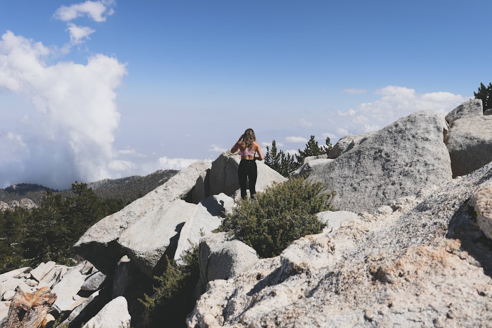 woman in black jacket sitting on rock during daytime