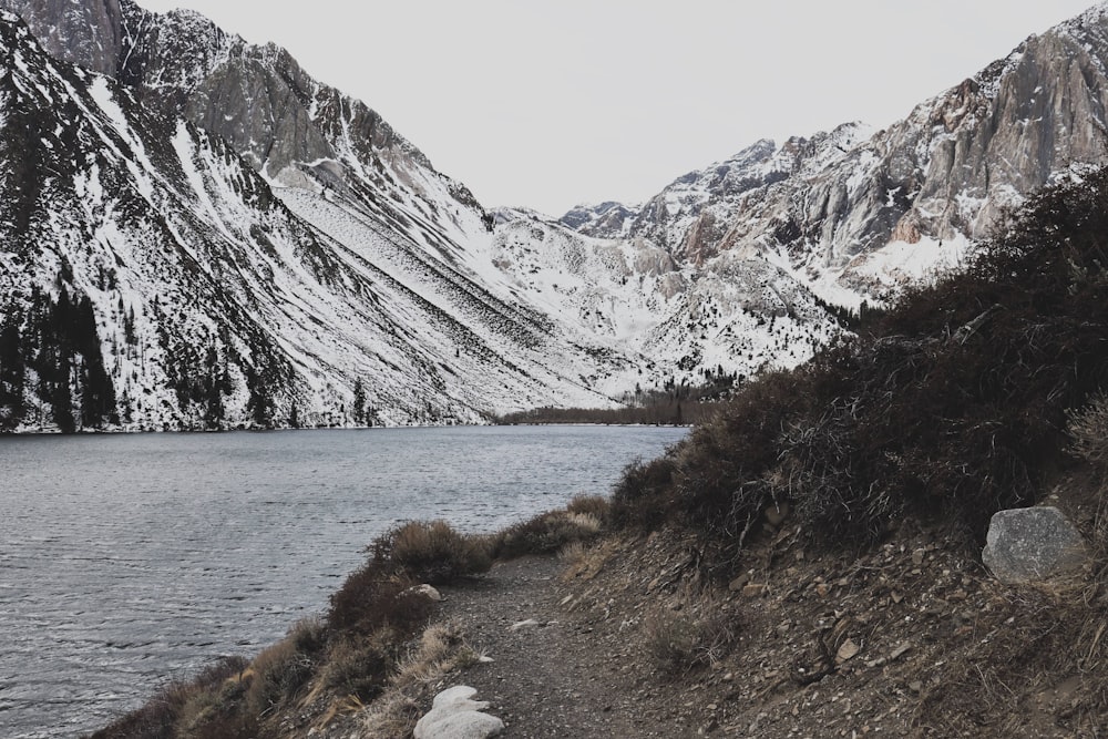 body of water near mountain during daytime