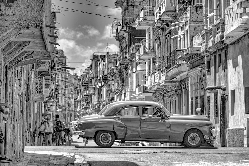 foto em tons de cinza do carro clássico na rua