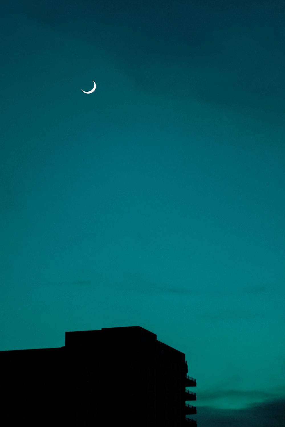 crescent moon over black building