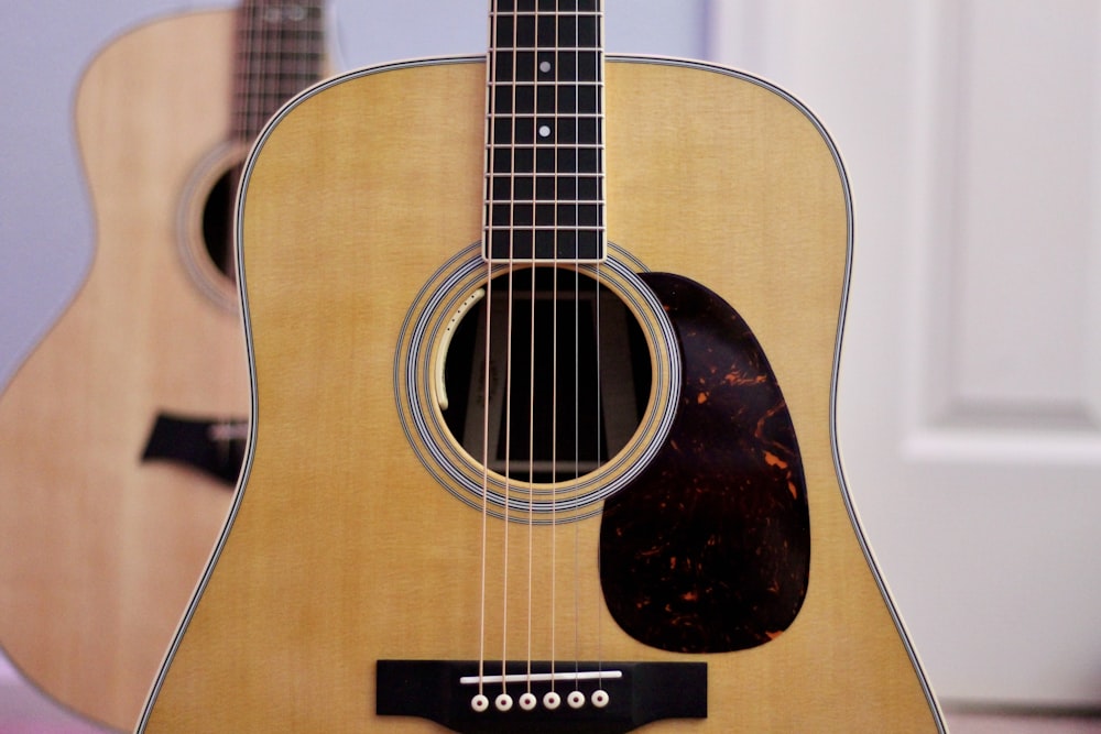 brown acoustic guitar on brown wooden table