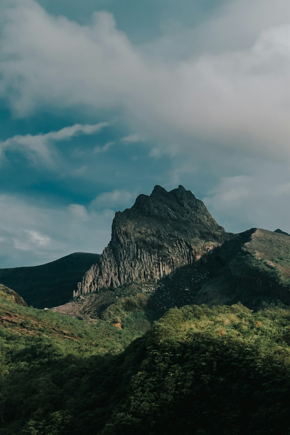 green and brown mountain under white clouds and blue sky during daytime