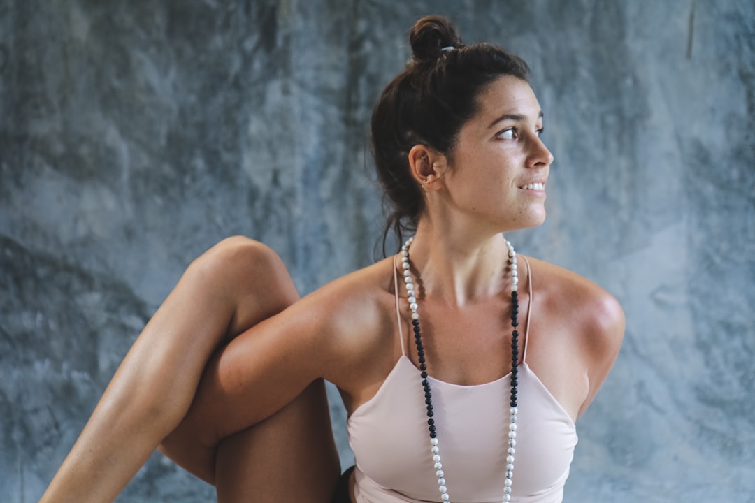 woman in white tank top and white beaded necklace, Yogi: @avital.yoga