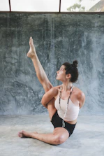 woman in white tank top and black shorts raising her hands