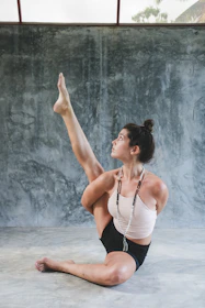 woman in white tank top and black shorts raising her hands