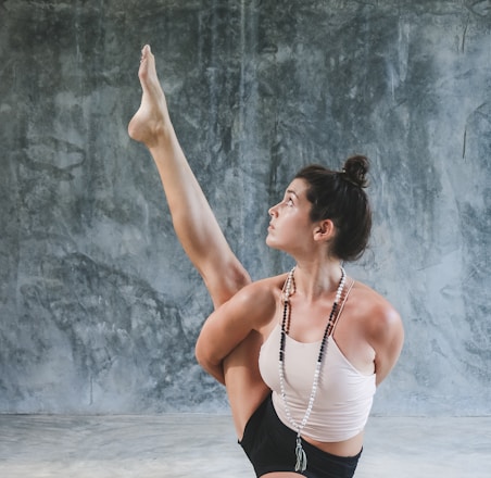 woman in white tank top and black shorts raising her hands