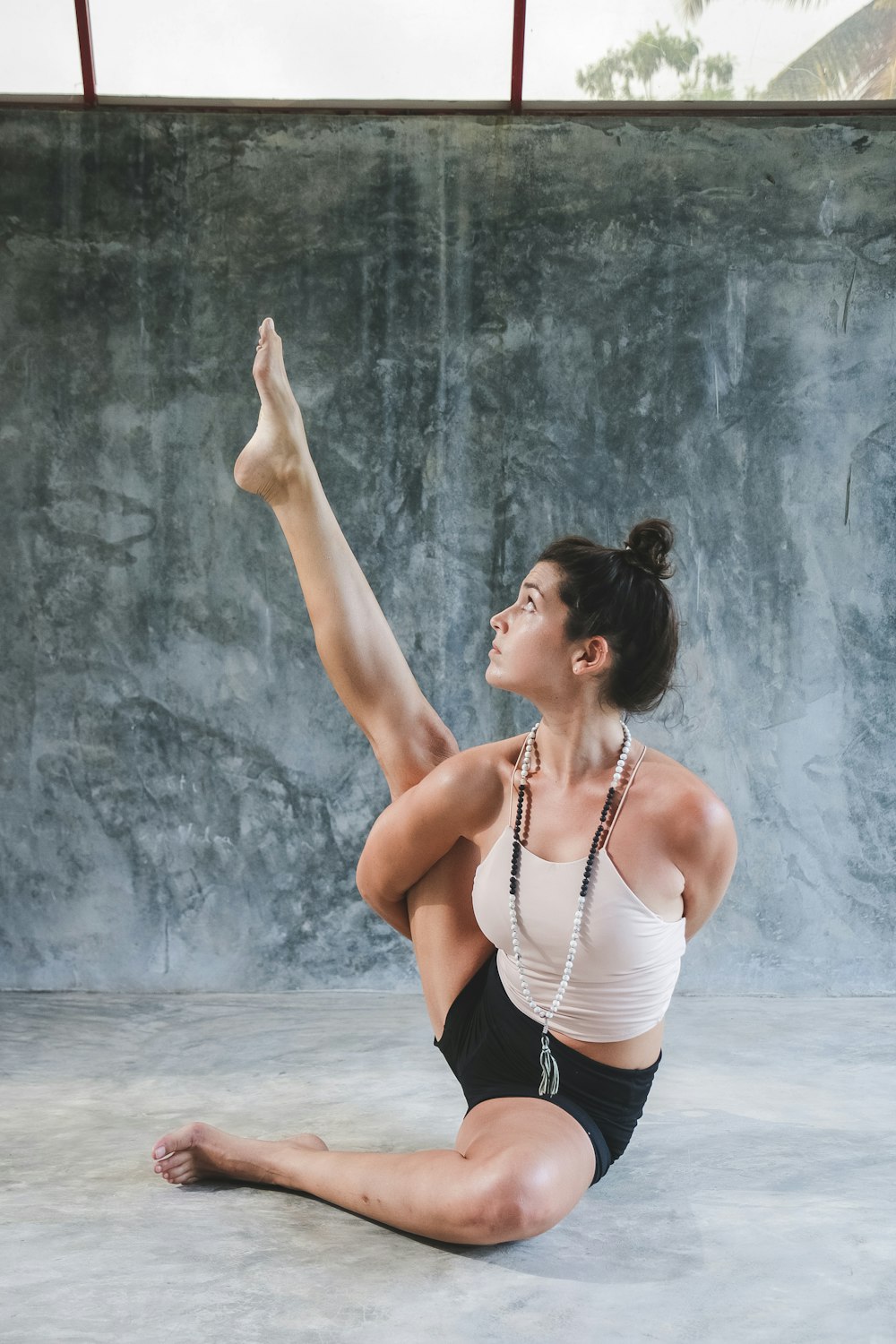 woman in white tank top and black shorts raising her hands