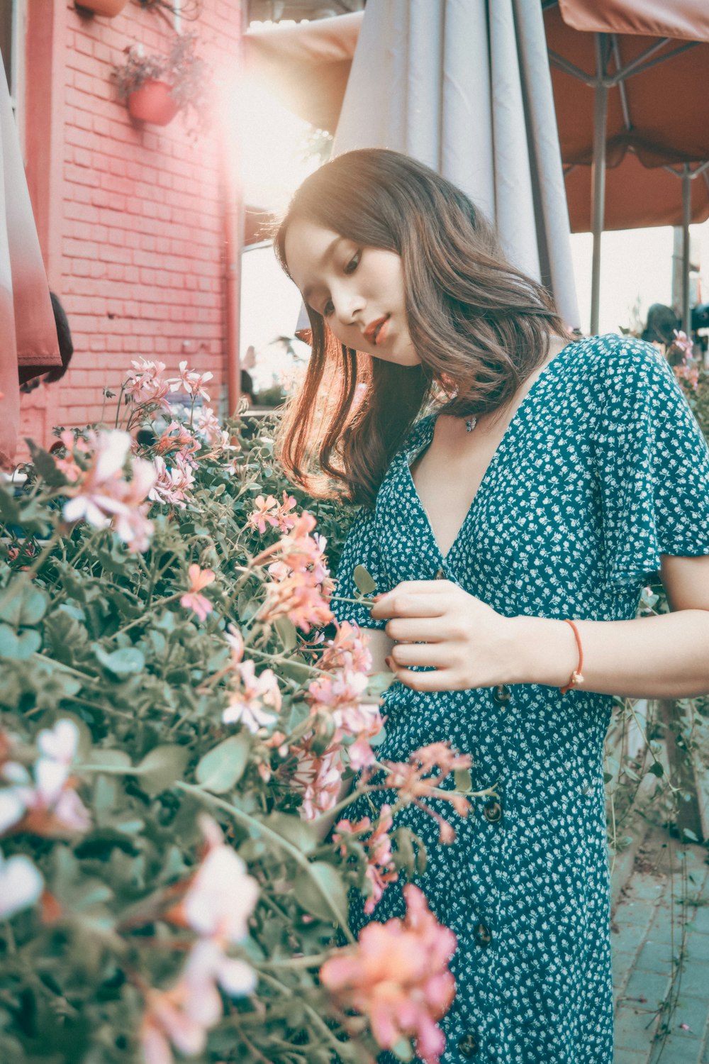 woman in black and white floral dress holding white and pink flowers