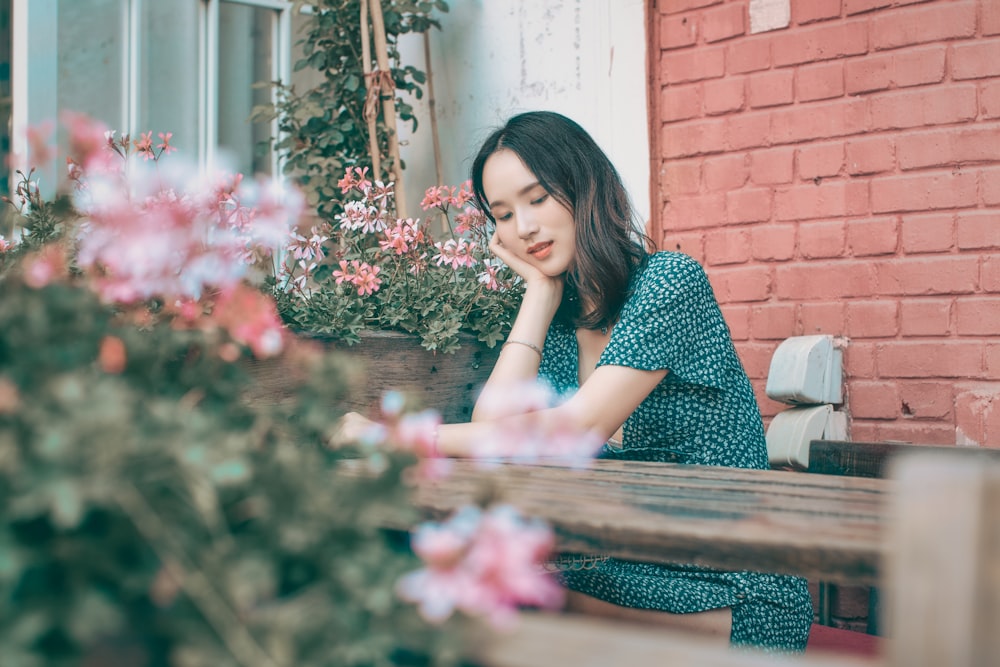 woman in black and white polka dot dress sitting on brown wooden bench