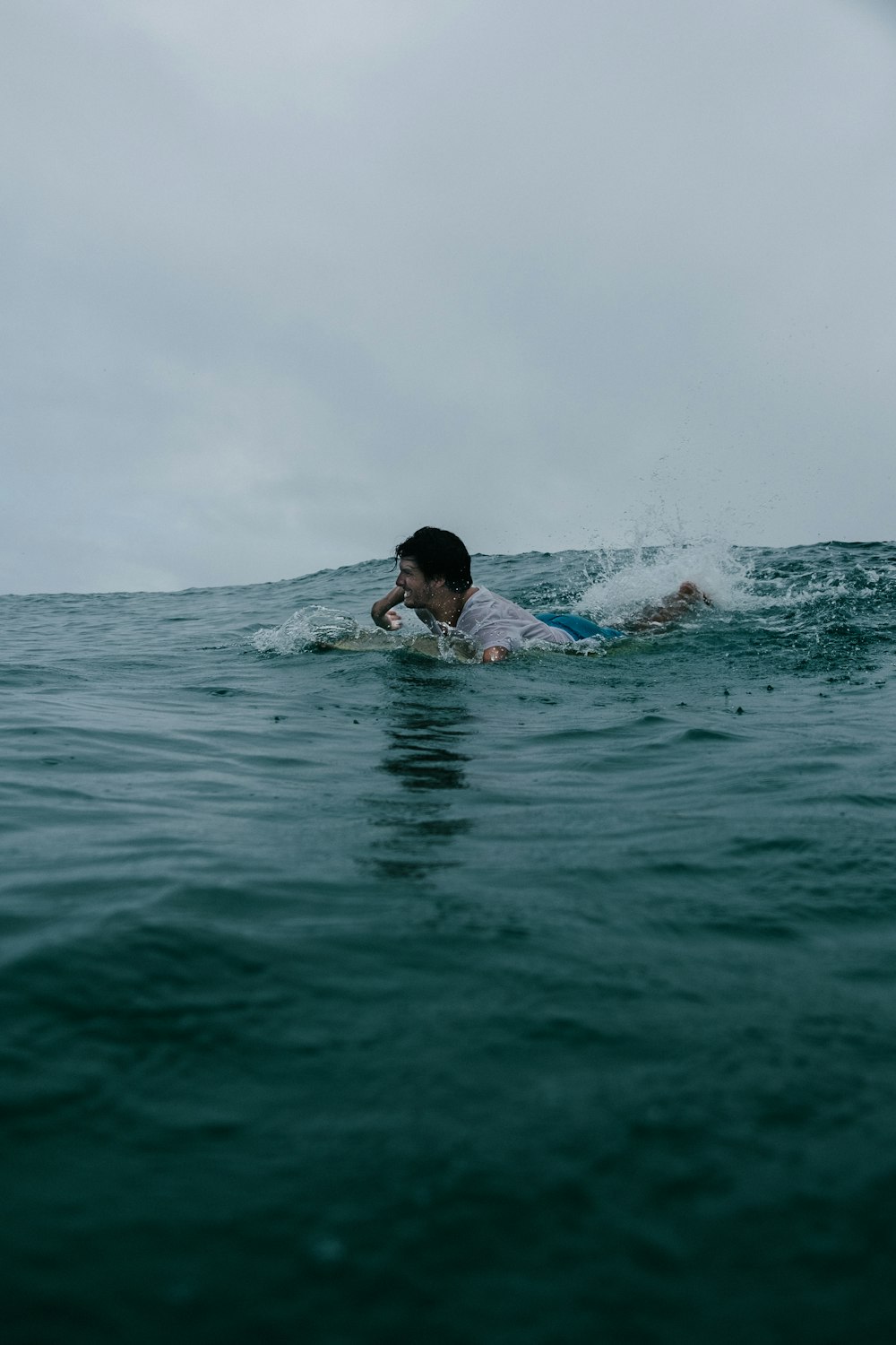 man in blue swimming trunks in water