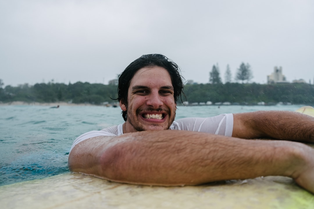 man in white tank top smiling