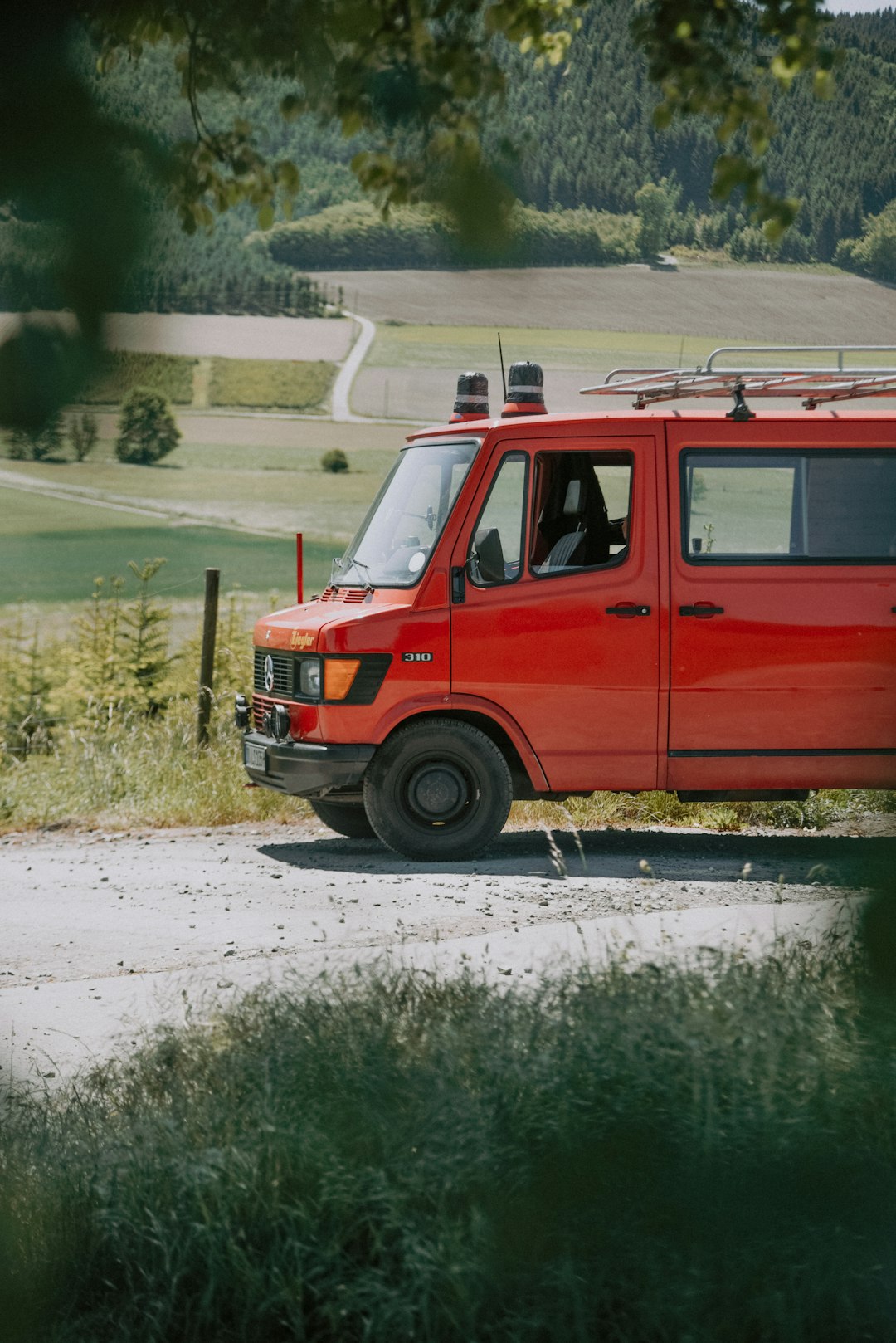 red van on gray asphalt road during daytime