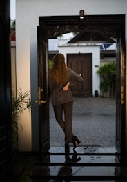 woman in brown coat standing near door