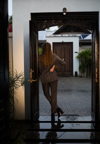 woman in brown coat standing near door