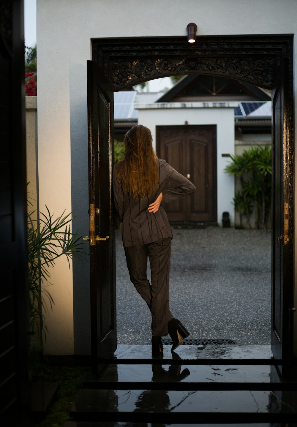 woman in brown coat standing near door