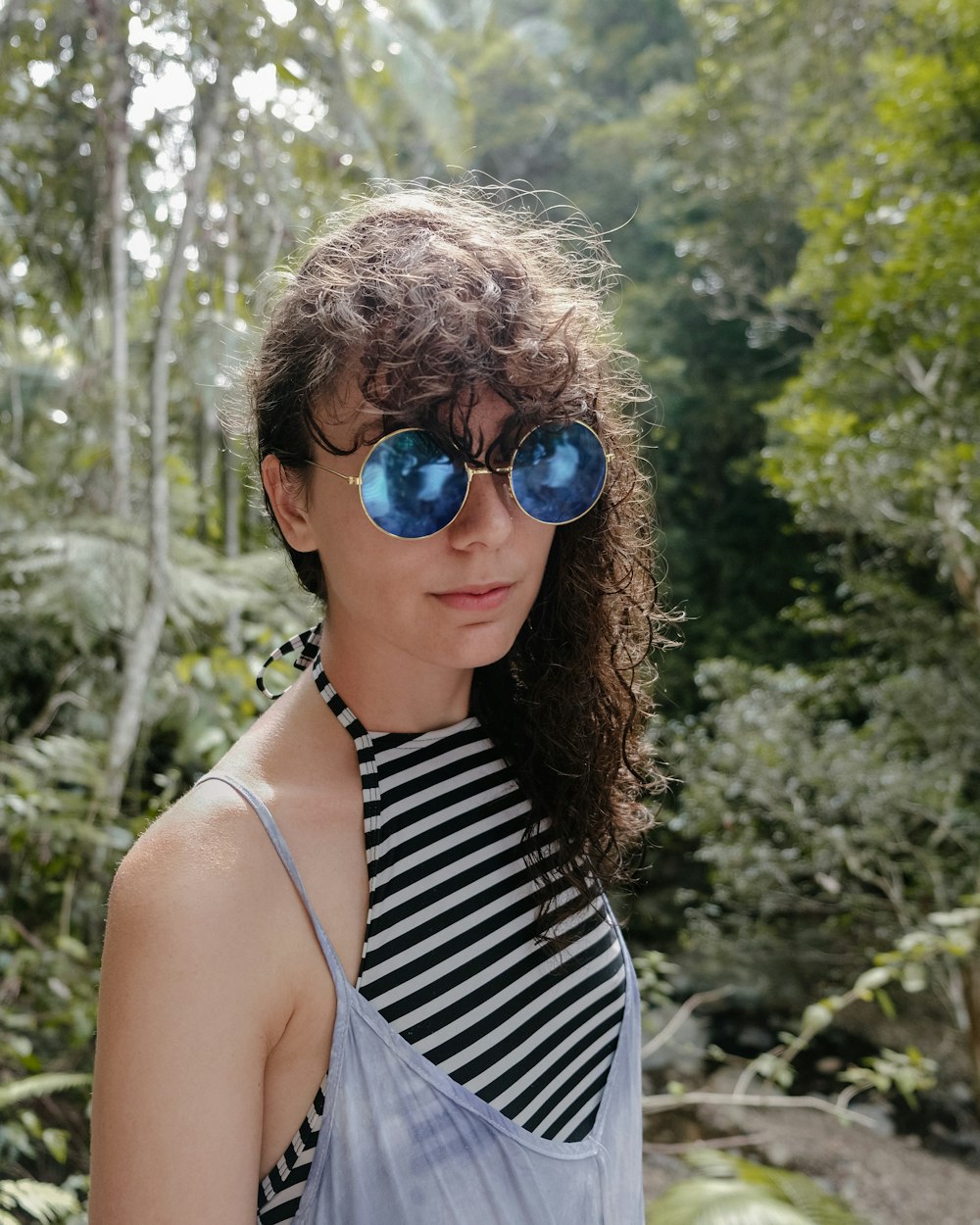 woman in white and black stripe tank top wearing blue sunglasses
