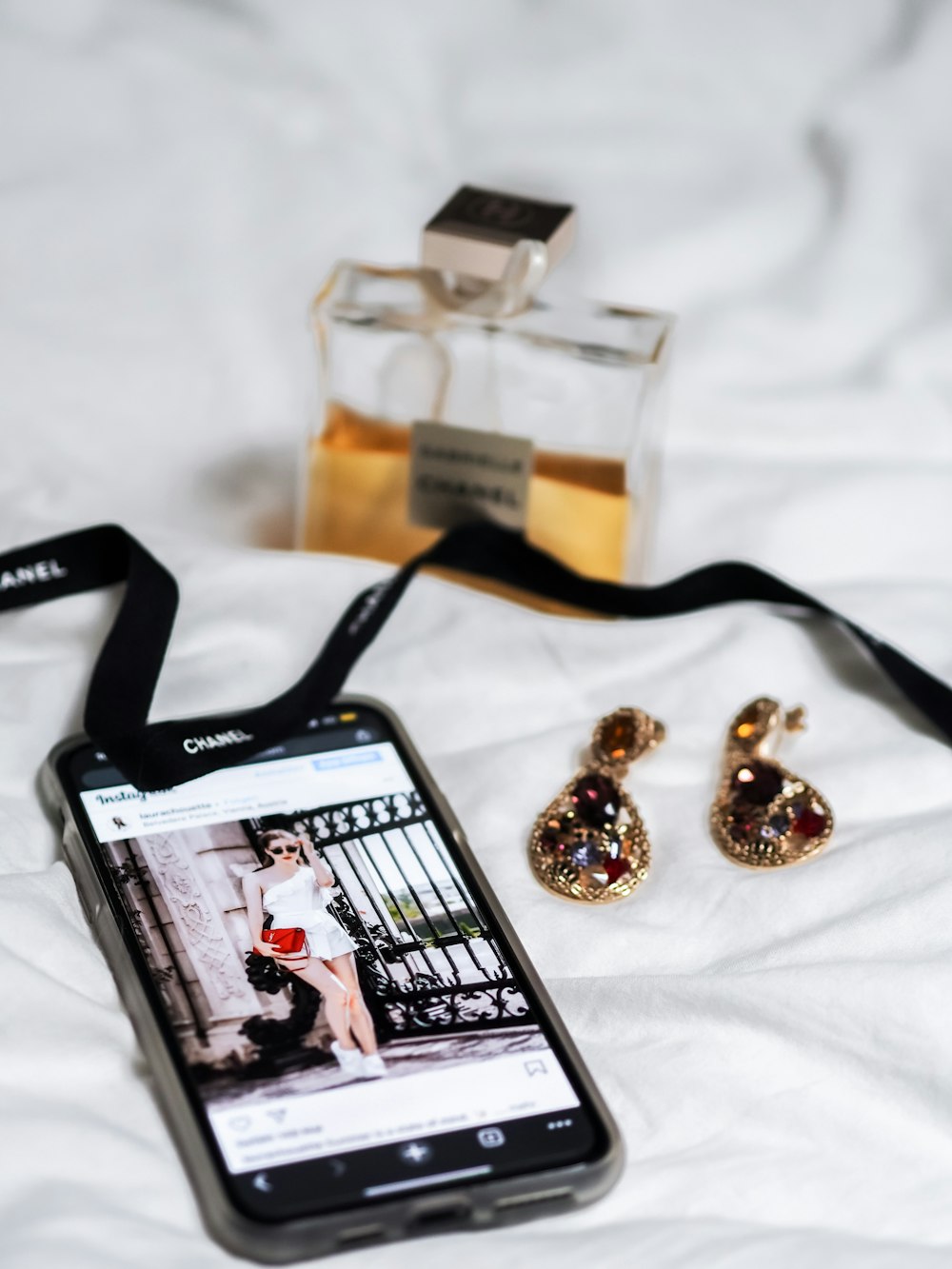 gold and silver beaded bracelet beside perfume bottle