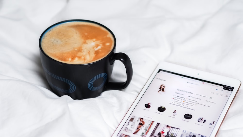 Tasse en céramique noire avec un liquide brun à l’intérieur