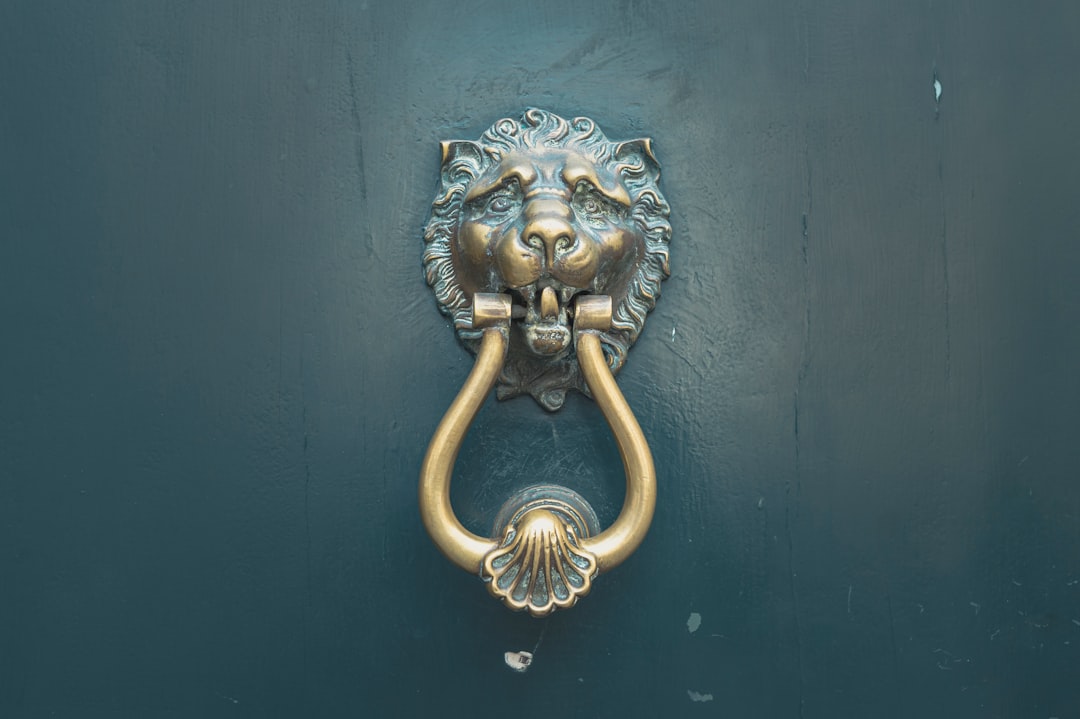 gold lion door handle on blue wooden door