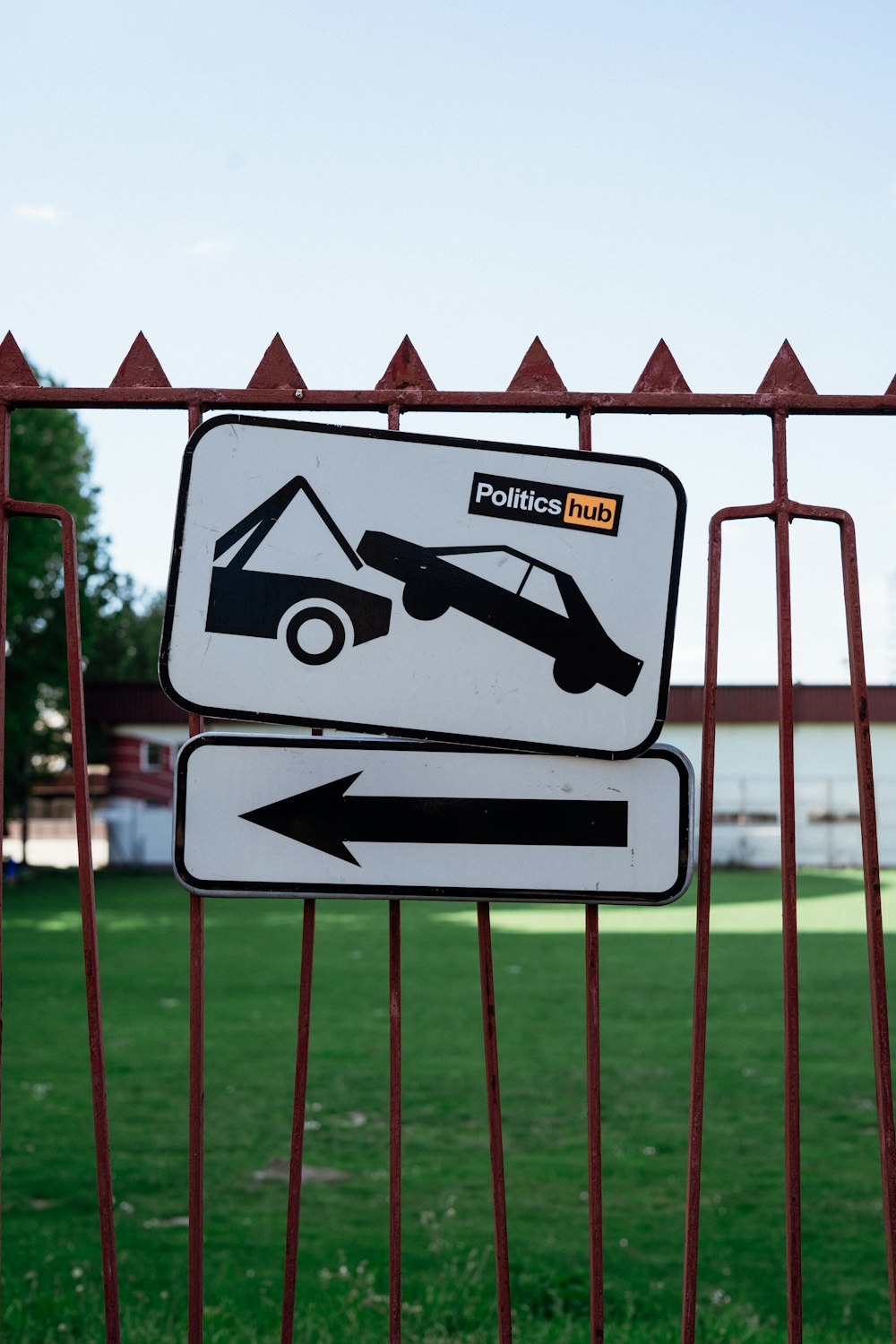 a white sign with a black arrow pointing to a tow truck