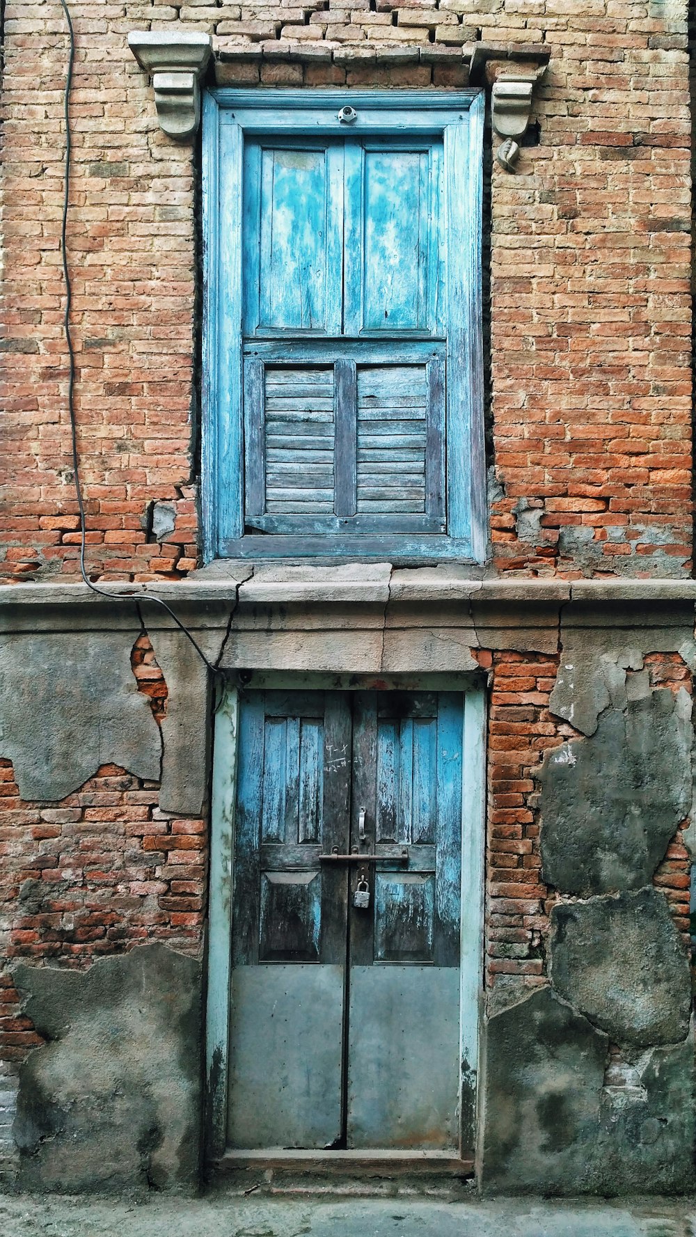 blue wooden door on brown brick wall