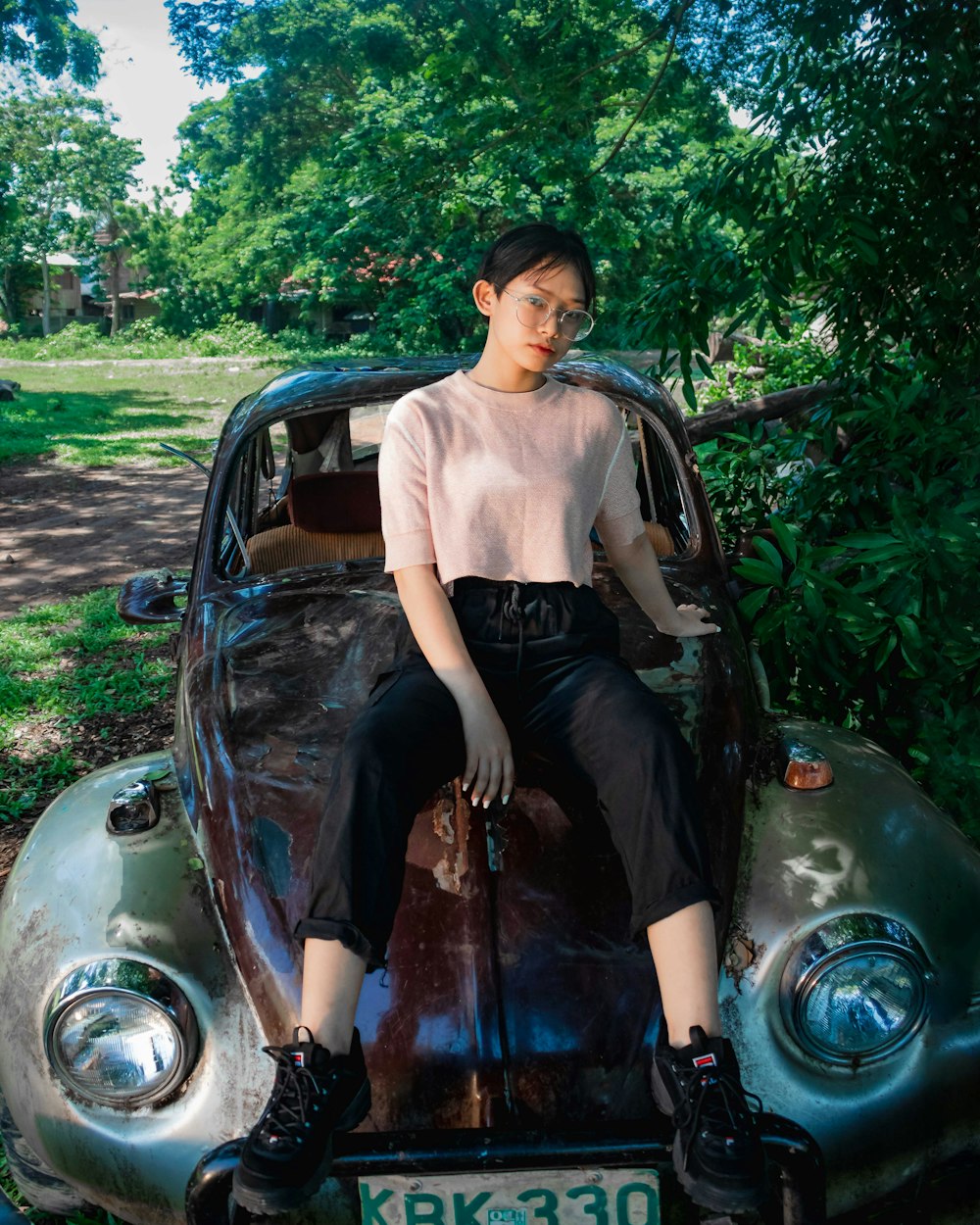 woman in black dress sitting on black car