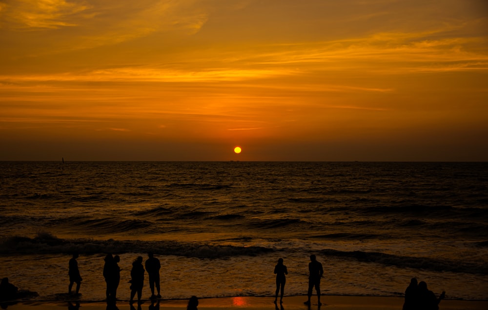 silhouette of people on beach during sunset