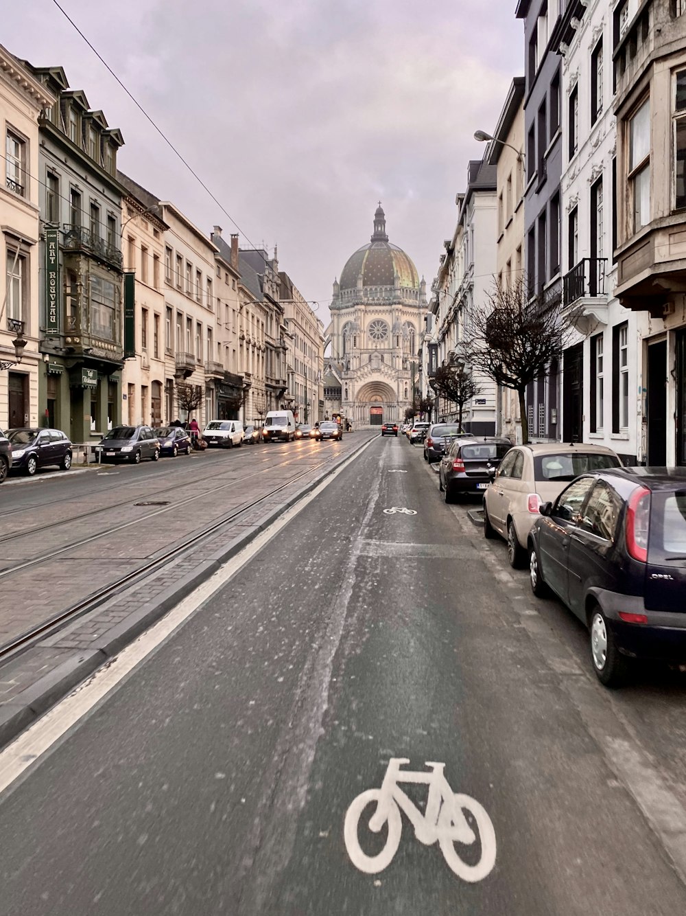 Auto parcheggiate sul lato della strada vicino a un edificio in cemento marrone durante il giorno