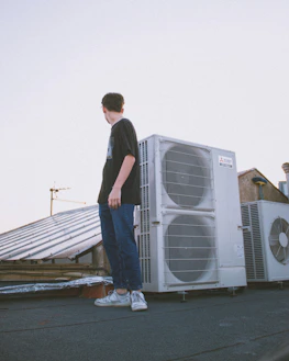 man in blue denim jeans standing on gray wooden dock during daytime