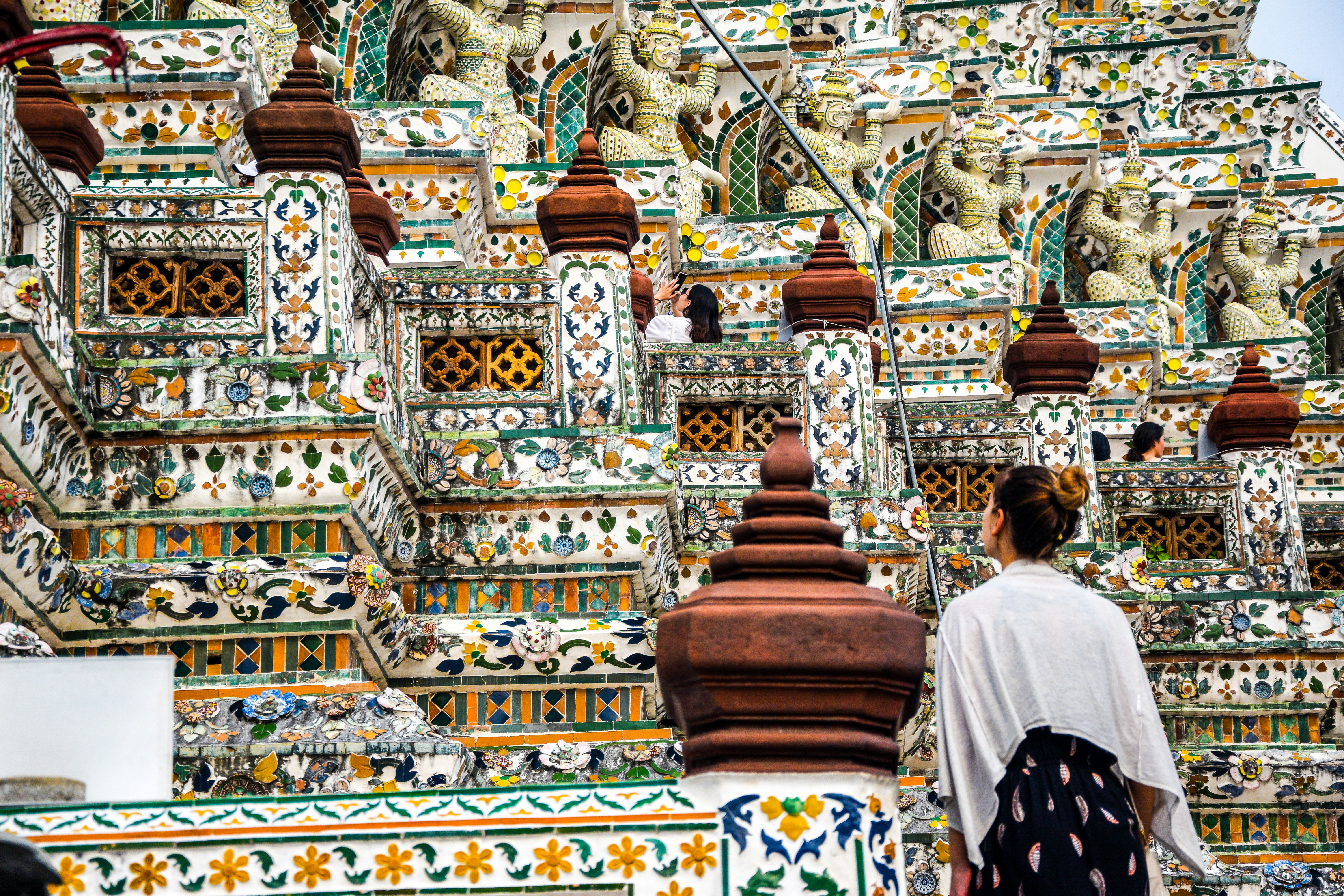 people walking on gold and white temple during daytime buddhist temple teams background