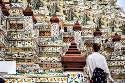 people walking on gold and white temple during daytime buddhist temple teams background