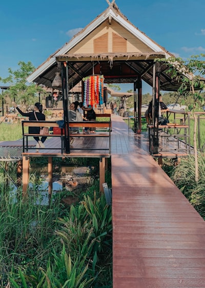 brown wooden gazebo near green plants during daytime