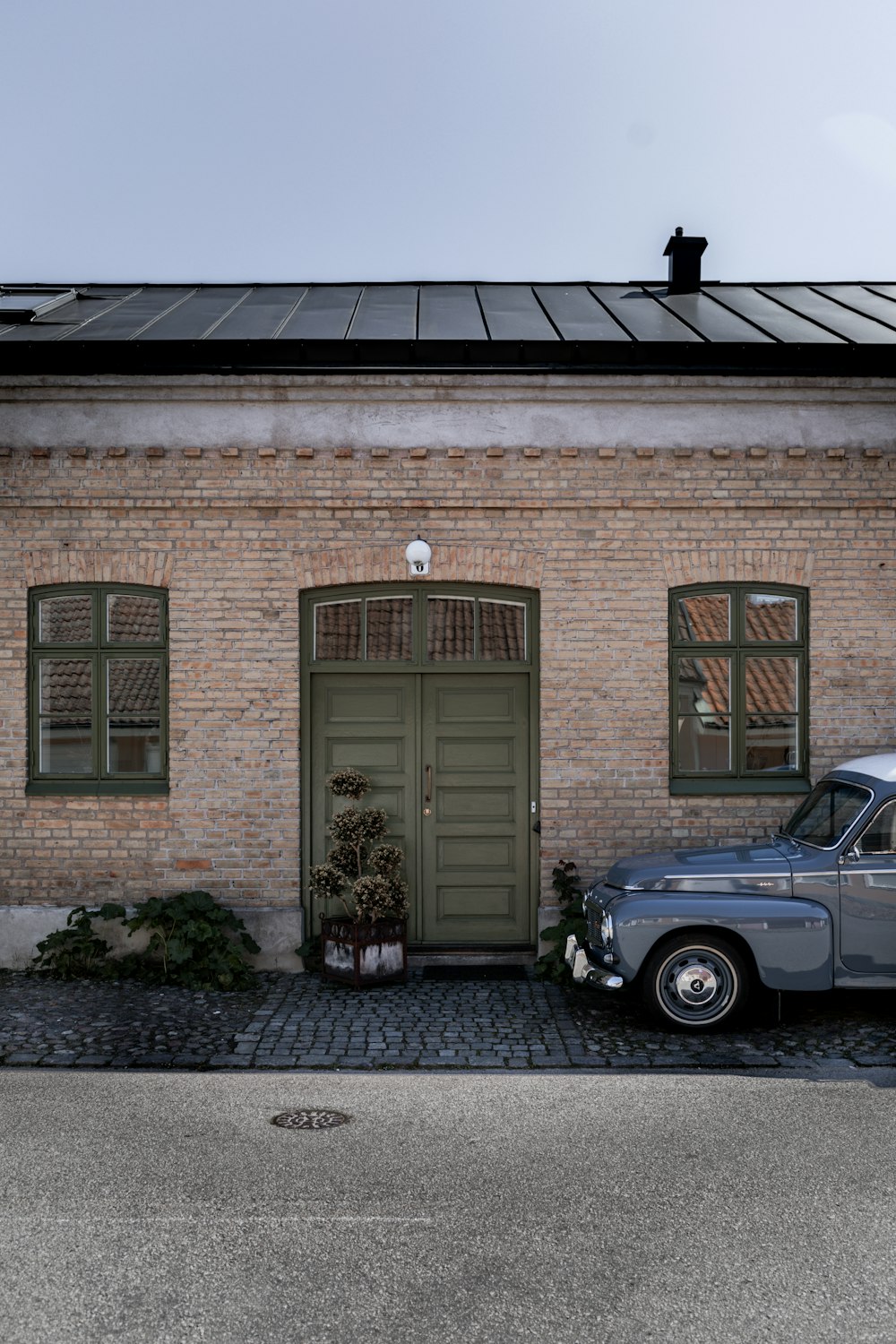 white car parked in front of brown brick building