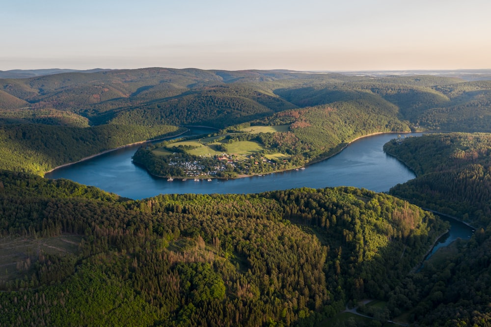 aerial view of green and brown mountains and lake