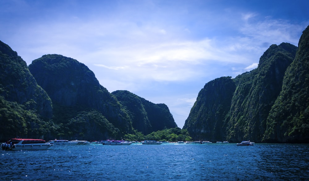 green and black mountain beside body of water during daytime