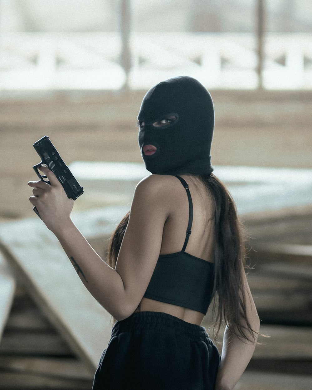 黒いスマートフォンを持つ黒いタンクトップの女性