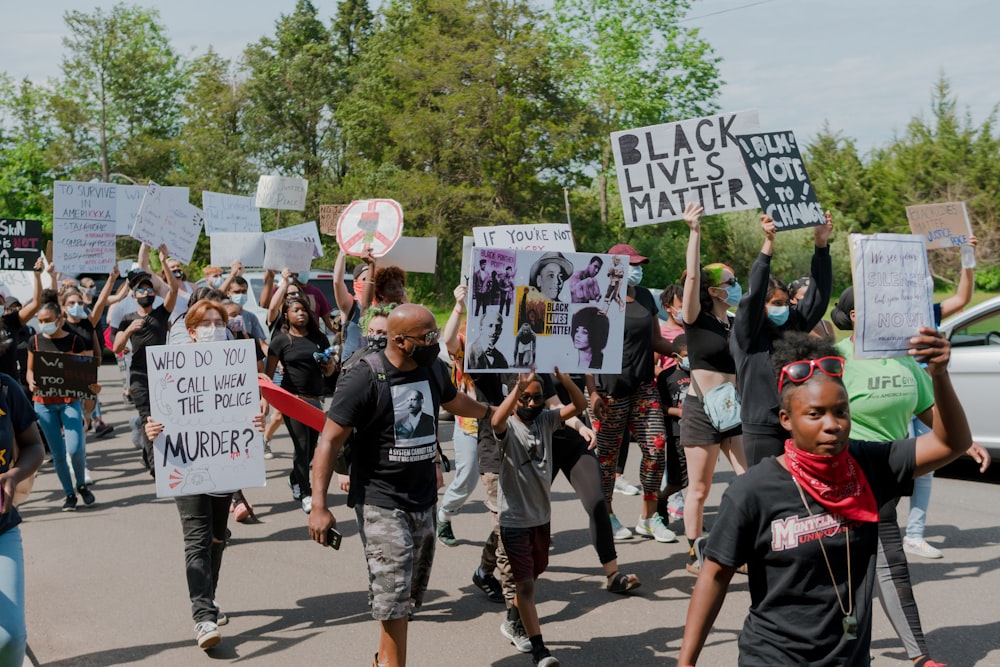 people holding white and blue banner during daytime