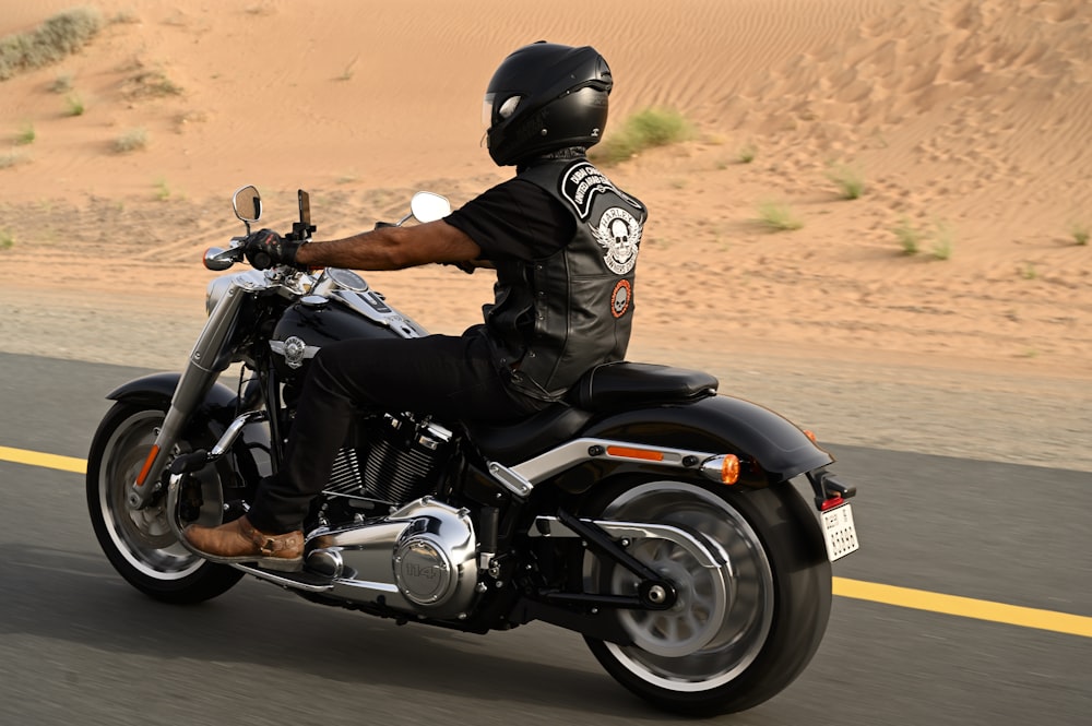 man in black leather jacket riding black motorcycle during daytime