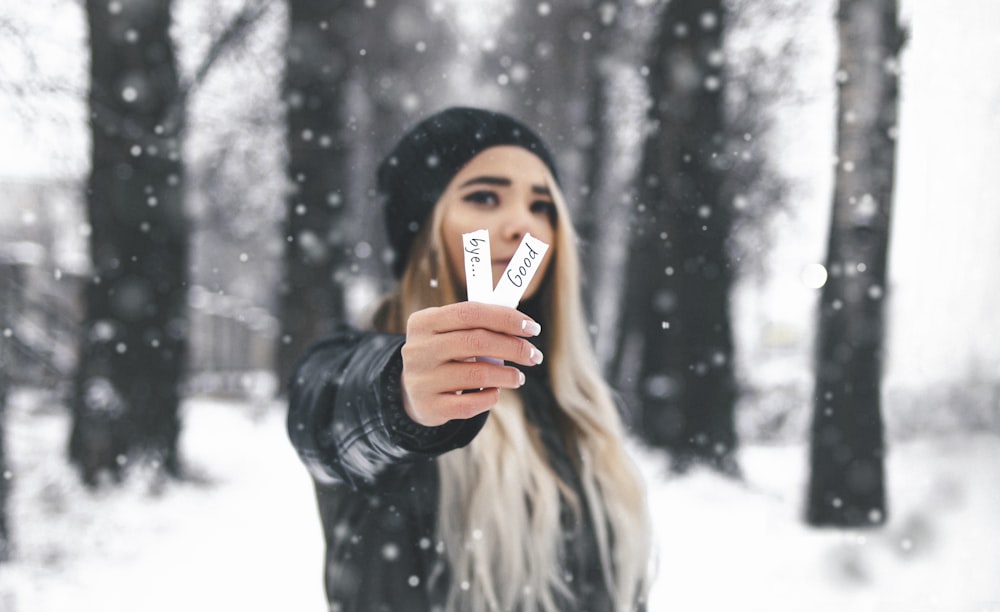 woman in black leather jacket covering her face with her hand