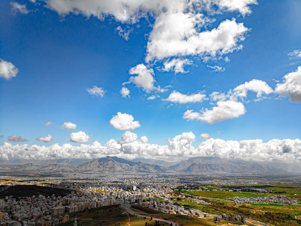 aerial view of city under blue sky and white clouds during daytime