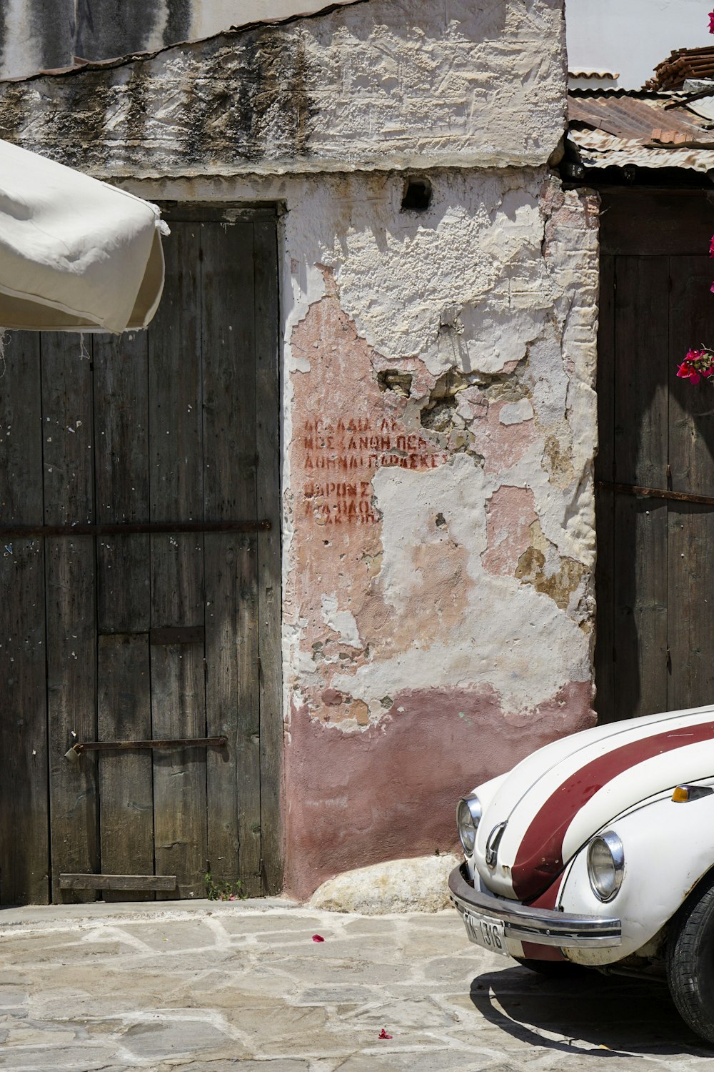 red and white car parked beside brown wooden door