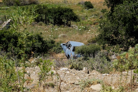blue car on brown dirt road during daytime in Naxos Greece