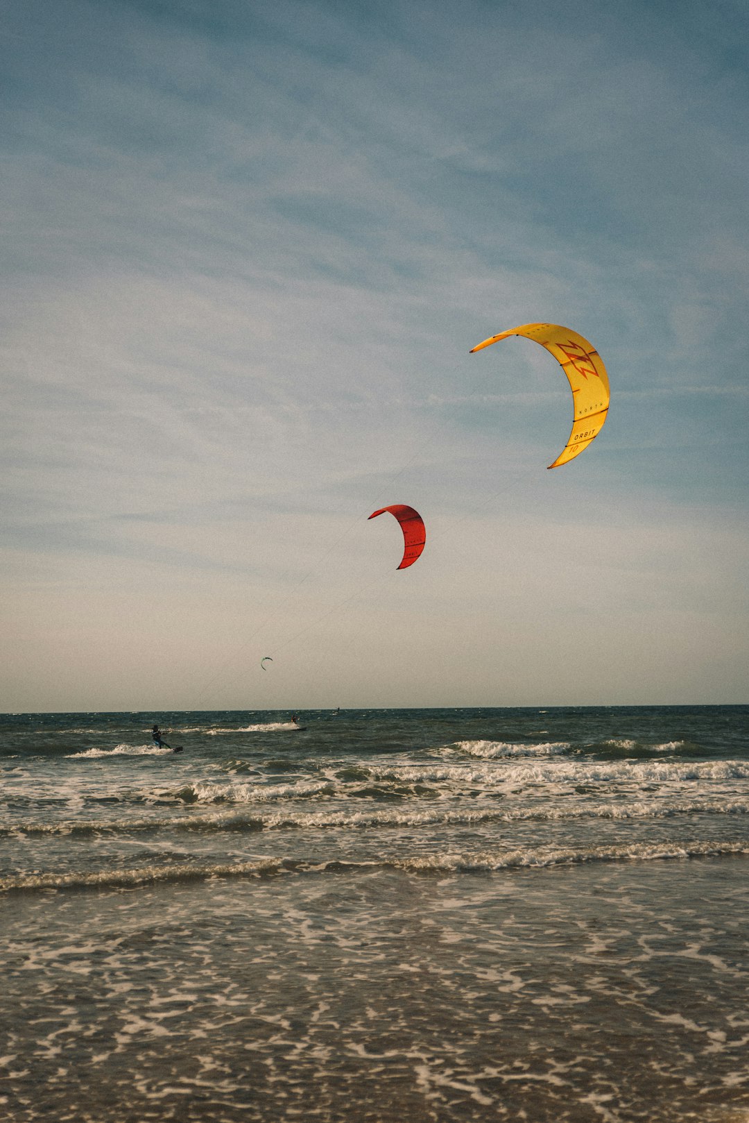 person in yellow parachute over sea during daytime