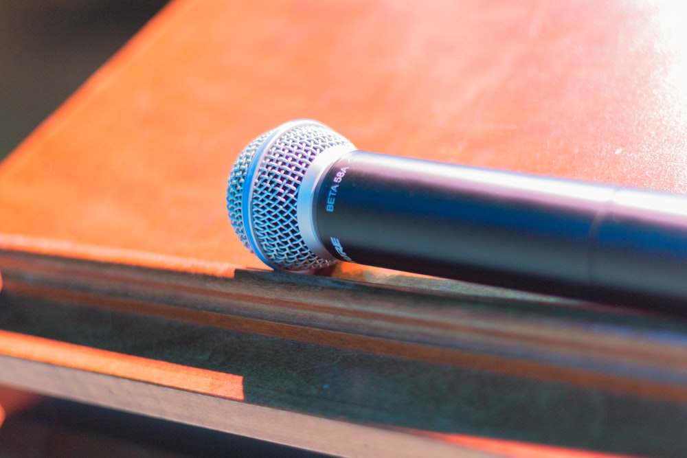 black and silver microphone on brown wooden table