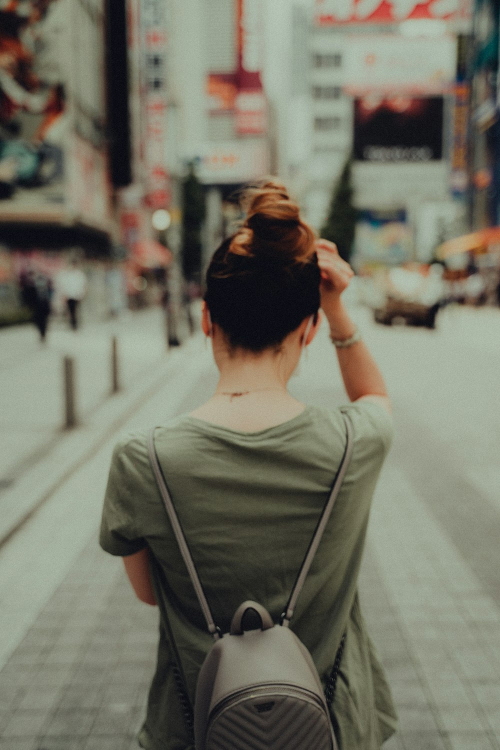 man in gray crew neck t-shirt standing on sidewalk during daytime