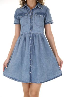 A casual denim shirt dress styled with sandals on a city street on a sunny afternoon.