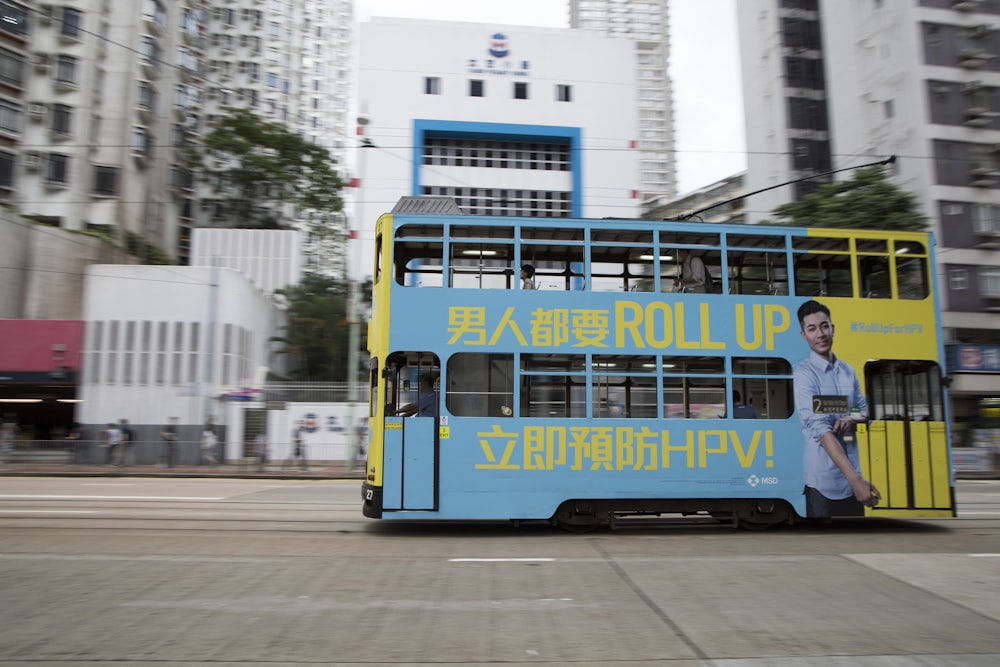 blue and yellow bus on road during daytime