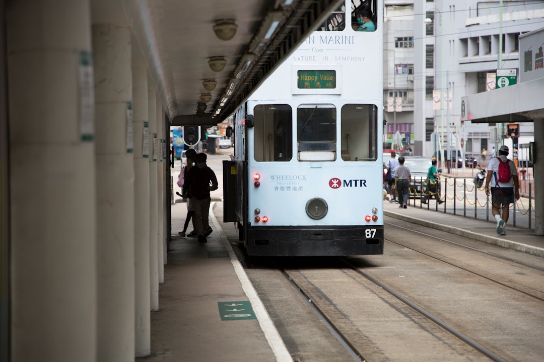 people walking on sidewalk near white train during daytime