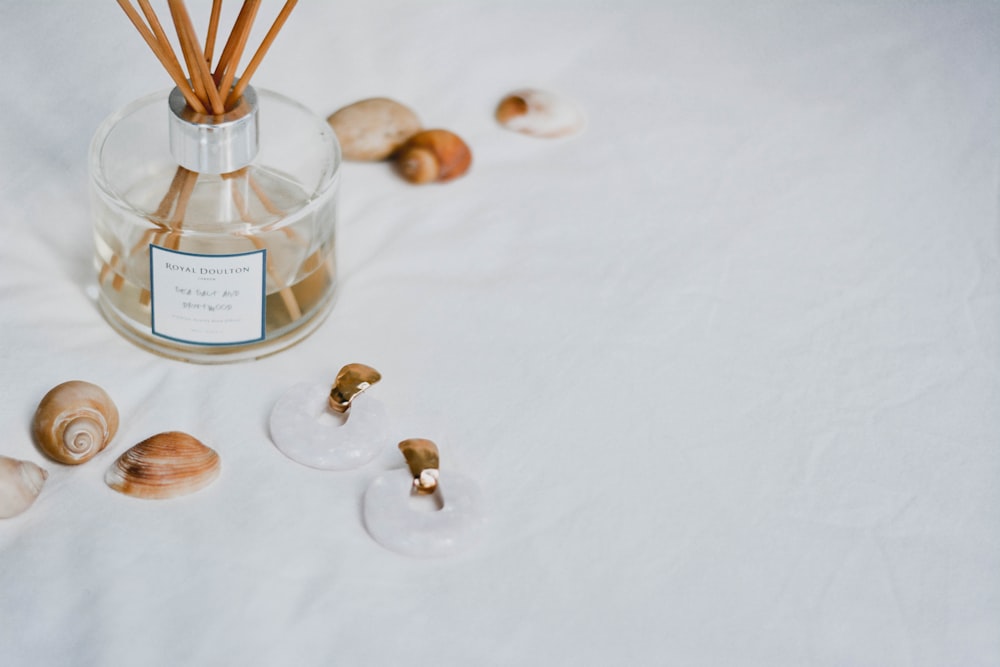 clear glass bottle on white textile