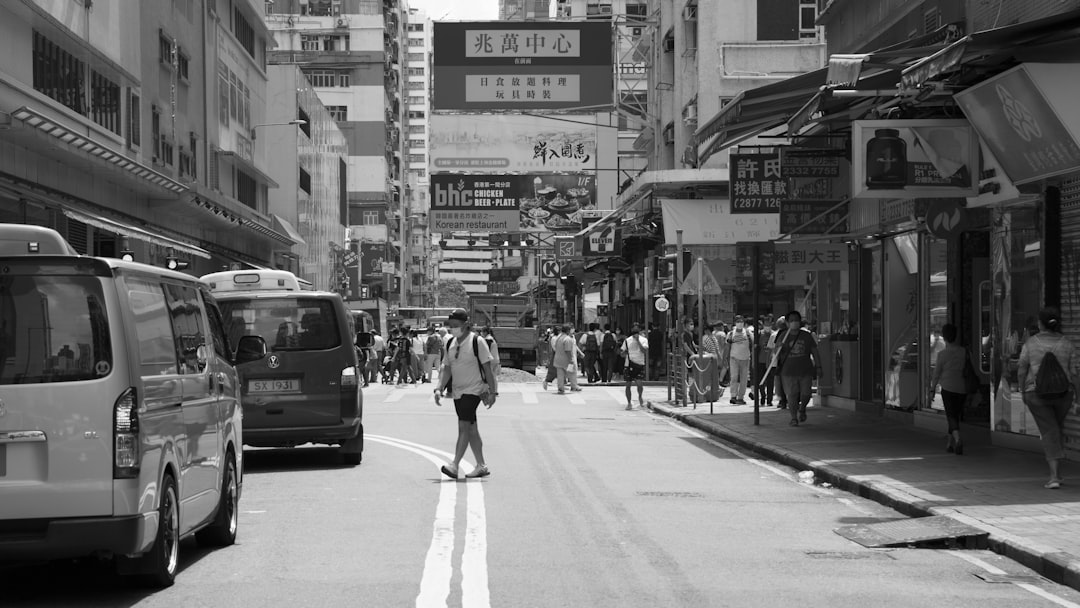 grayscale photo of woman walking on street